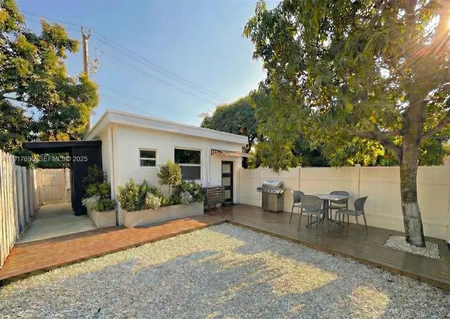 a view of a house with backyard sitting area and garden