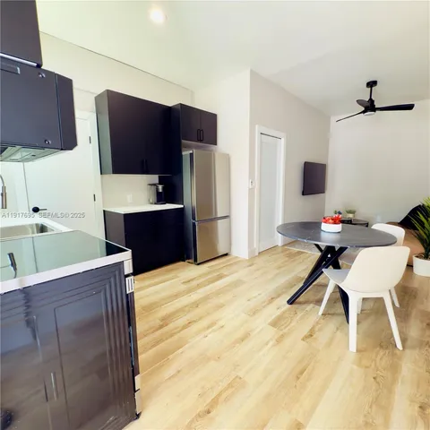 a kitchen with a wooden floor and a refrigerator