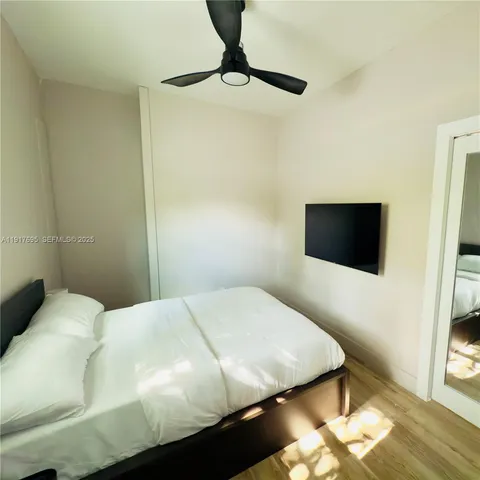 a bedroom with a bed and a flat screen tv