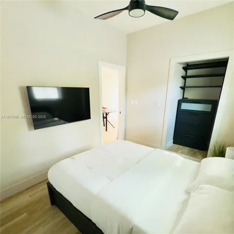 a bedroom with a bed and a flat screen tv