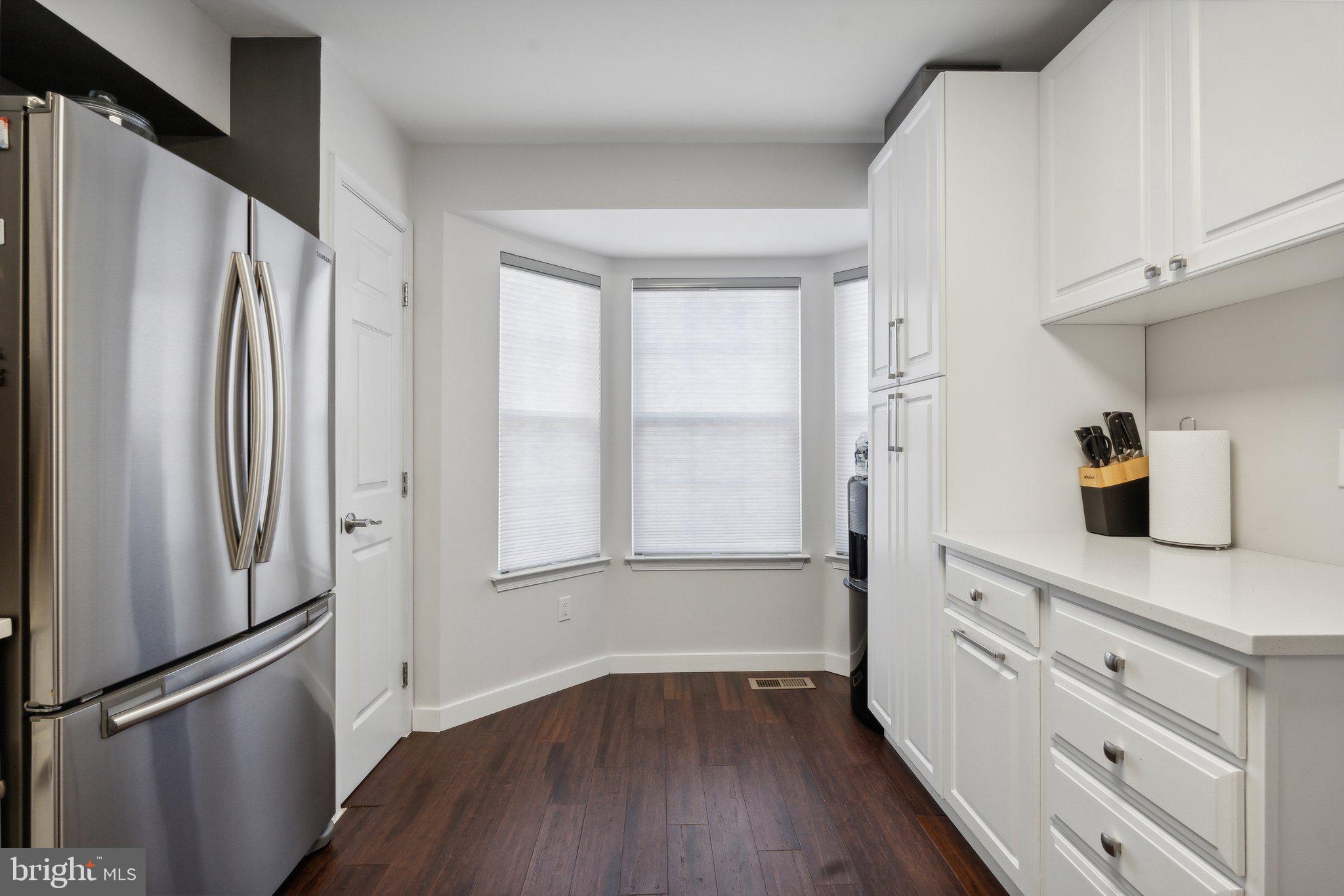 410 McDaniel Drive Purcellville, VA 20132 - Photo 12 of 36 a kitchen with white cabinets and wooden floor