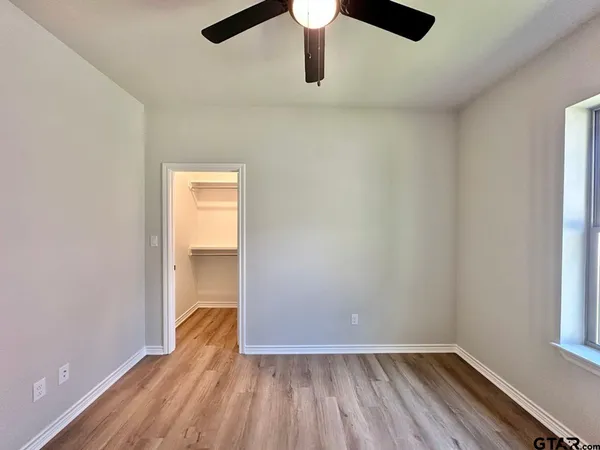 a view of empty room with wooden floor
