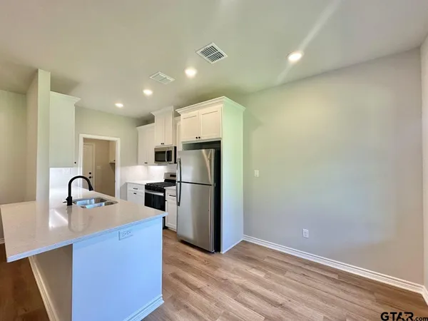 a kitchen with stainless steel appliances granite countertop a refrigerator sink and stove