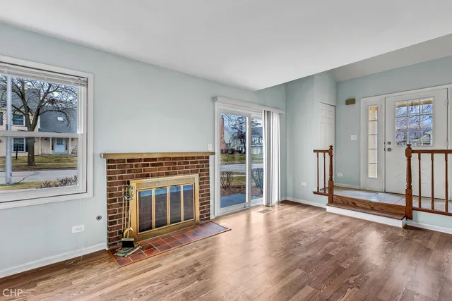 wooden floor fireplace and windows in an empty room