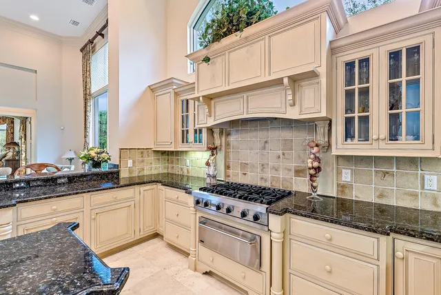 a kitchen with granite countertop a sink stainless steel appliances and cabinets