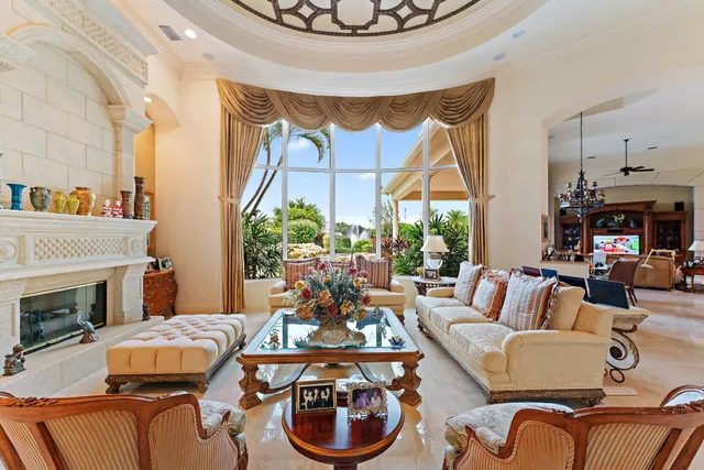 a living room with furniture a fireplace and a floor to ceiling window