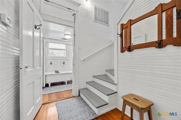 a bed sitting in a spacious bedroom next to a window