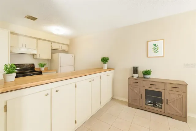 a kitchen with granite countertop white cabinets and stainless steel appliances