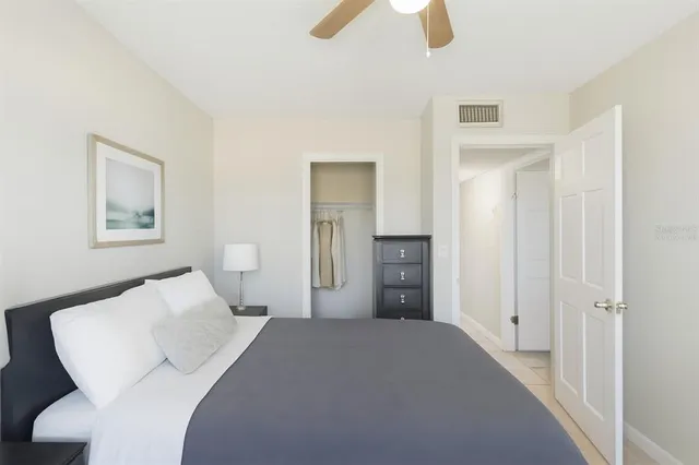 a bedroom with a bed and a painting on the wall