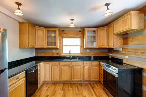 a kitchen with wooden floors and appliances