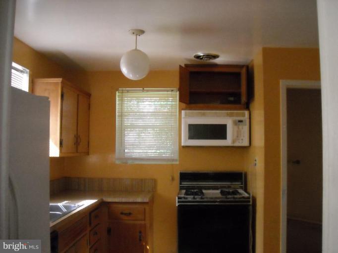 11810 Indigo Road Silver Spring, MD 20906 - Photo 5 of 7 a kitchen with stainless steel appliances a stove and a microwave