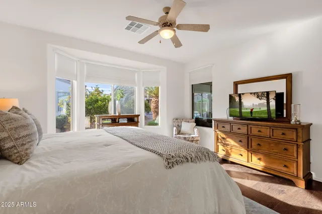 a bedroom with a large bed and a flat screen tv