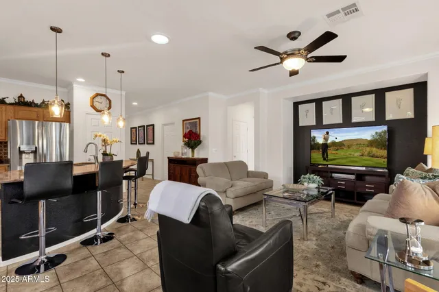 a living room with furniture a ceiling fan and a flat screen tv