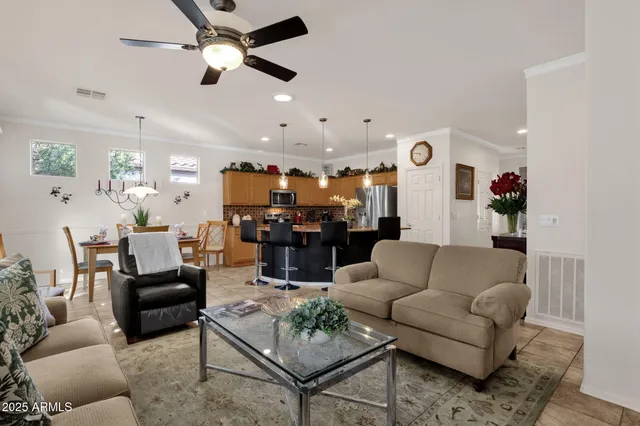a living room with furniture kitchen view and a chandelier