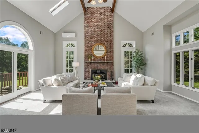 a living room with furniture a fireplace and a large window