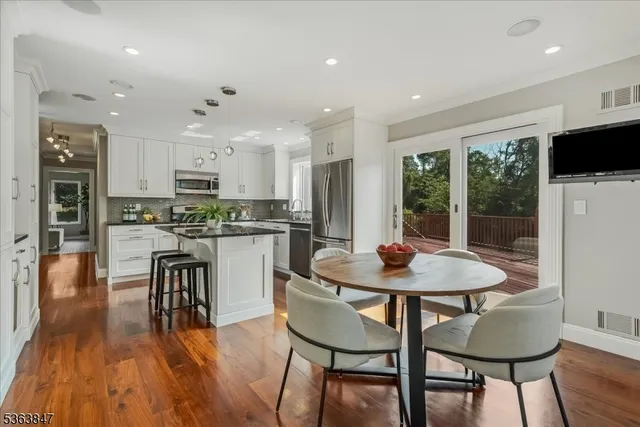 a kitchen with a dining table chairs and refrigerator