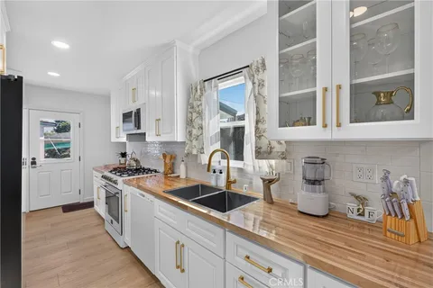 a kitchen with sink a stove and cabinets