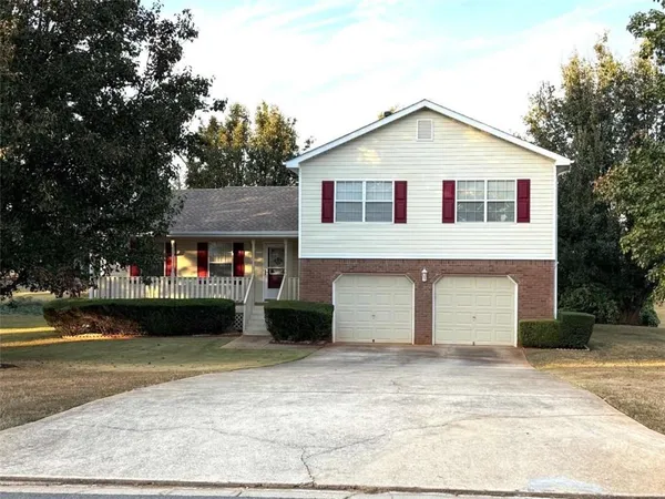 a view of a white house with a yard and garage