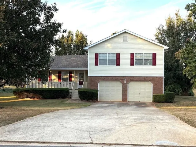 a view of a white house with a yard and garage