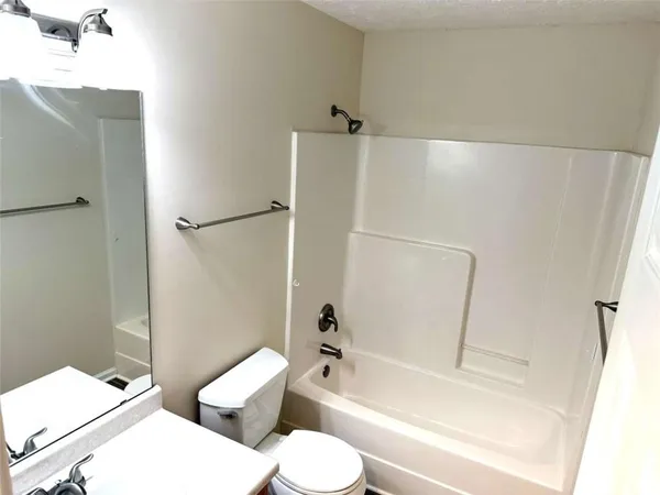 a white toilet sitting next to a bath tub