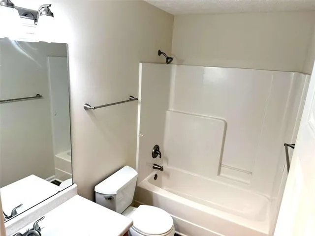 a white toilet sitting next to a bath tub