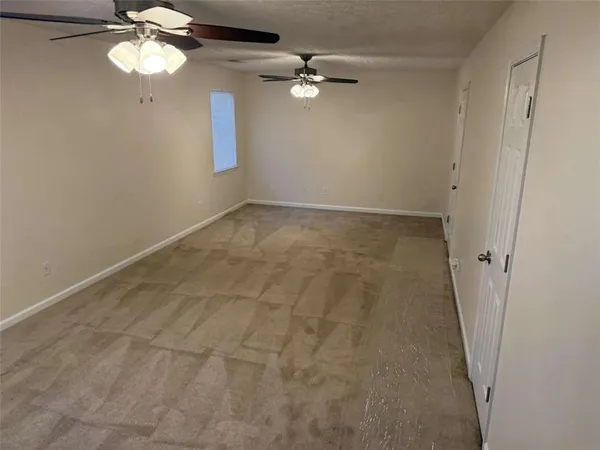 en empty room with windows and fan