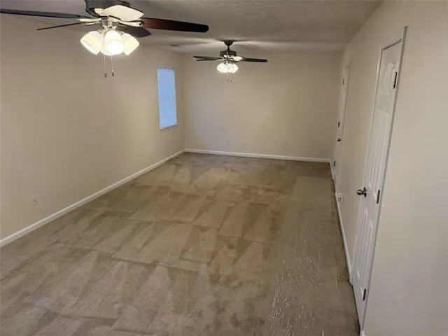 en empty room with windows and fan