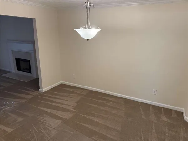 a view of a room with an empty space and a fireplace