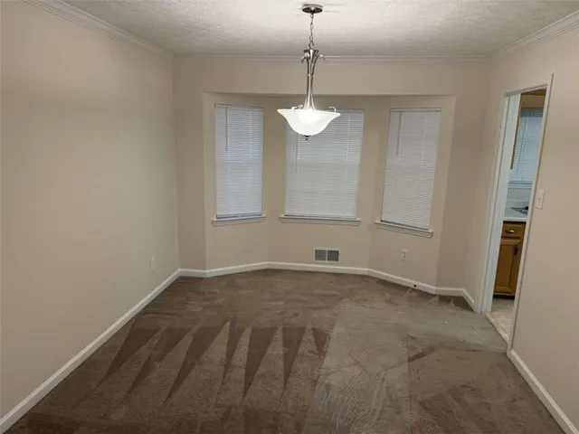 a view of an empty room with a chandelier fan