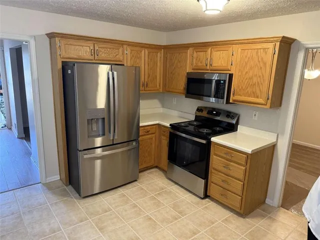 a kitchen with stainless steel appliances granite countertop a refrigerator stove and microwave