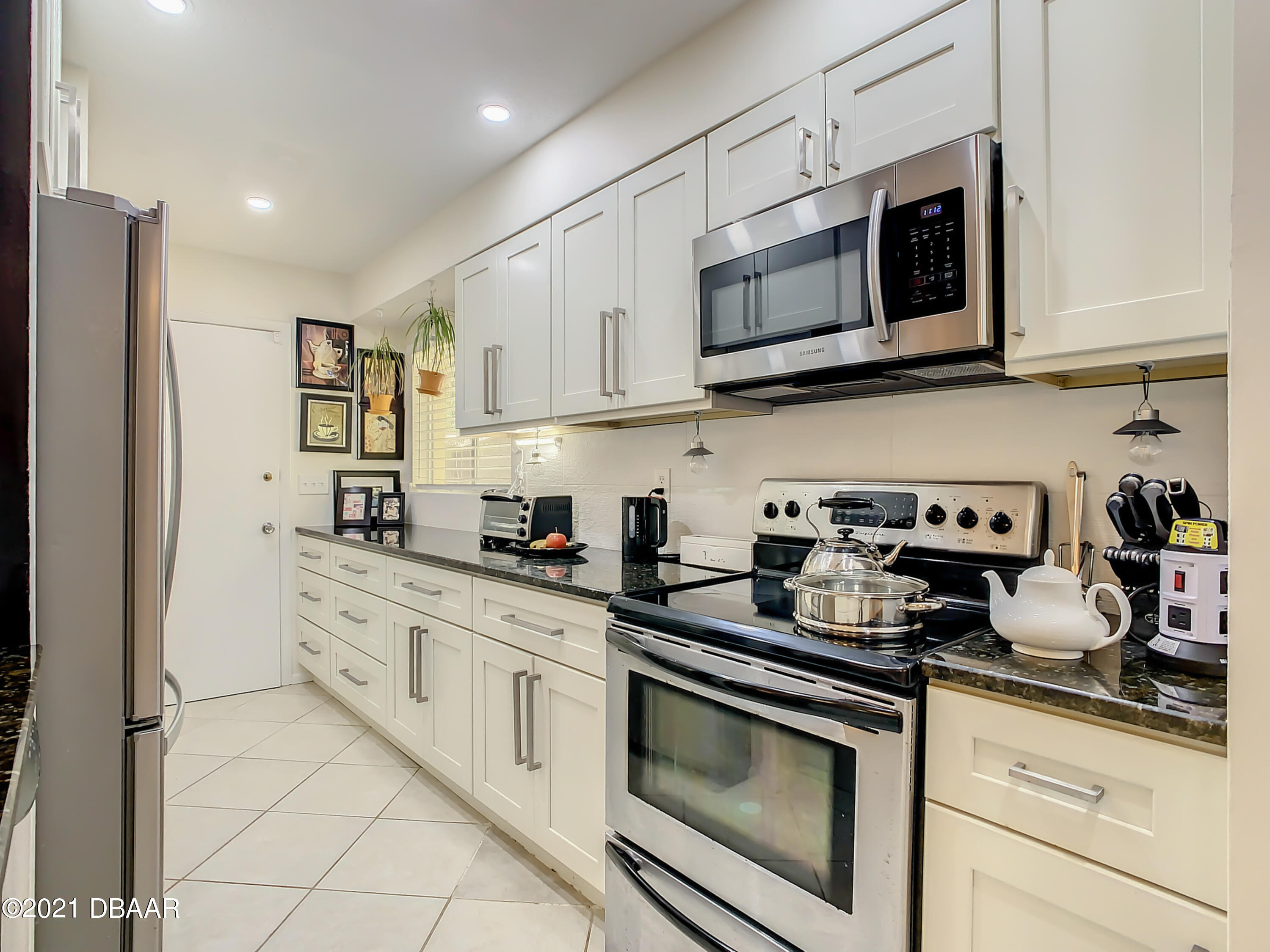 127 Cypress Pond Road Port Orange, FL 32128 - Photo 14 of 52 a kitchen with stainless steel appliances granite countertop a sink a stove a microwave and cabinets