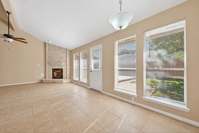 a view of an empty room with a fireplace and a window