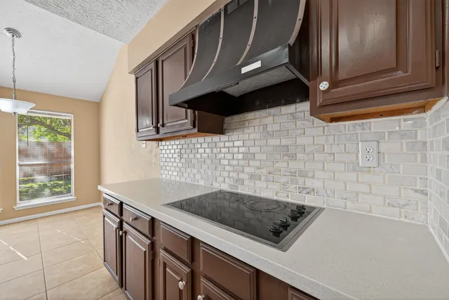a kitchen with granite countertop a stove a sink and a microwave