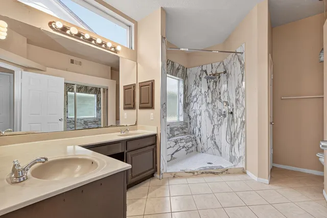 a bathroom with a sink a toilet and shower