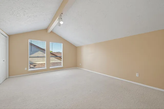 an empty room with windows and closet