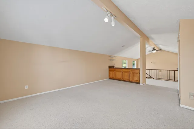 a view of a livingroom with wooden floor and stairs