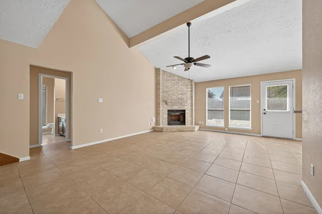 a view of an empty room with a fireplace and a window