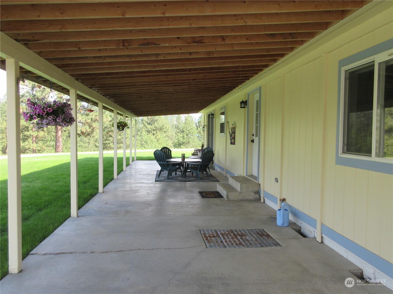 156 West Curlew Lake Road Republic, WA 99166 - Photo 22 of 36 a view of a patio with table and chairs potted plants with floor to ceiling window