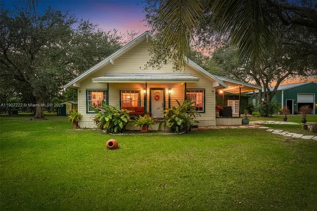 a front view of a house with a garden and trees