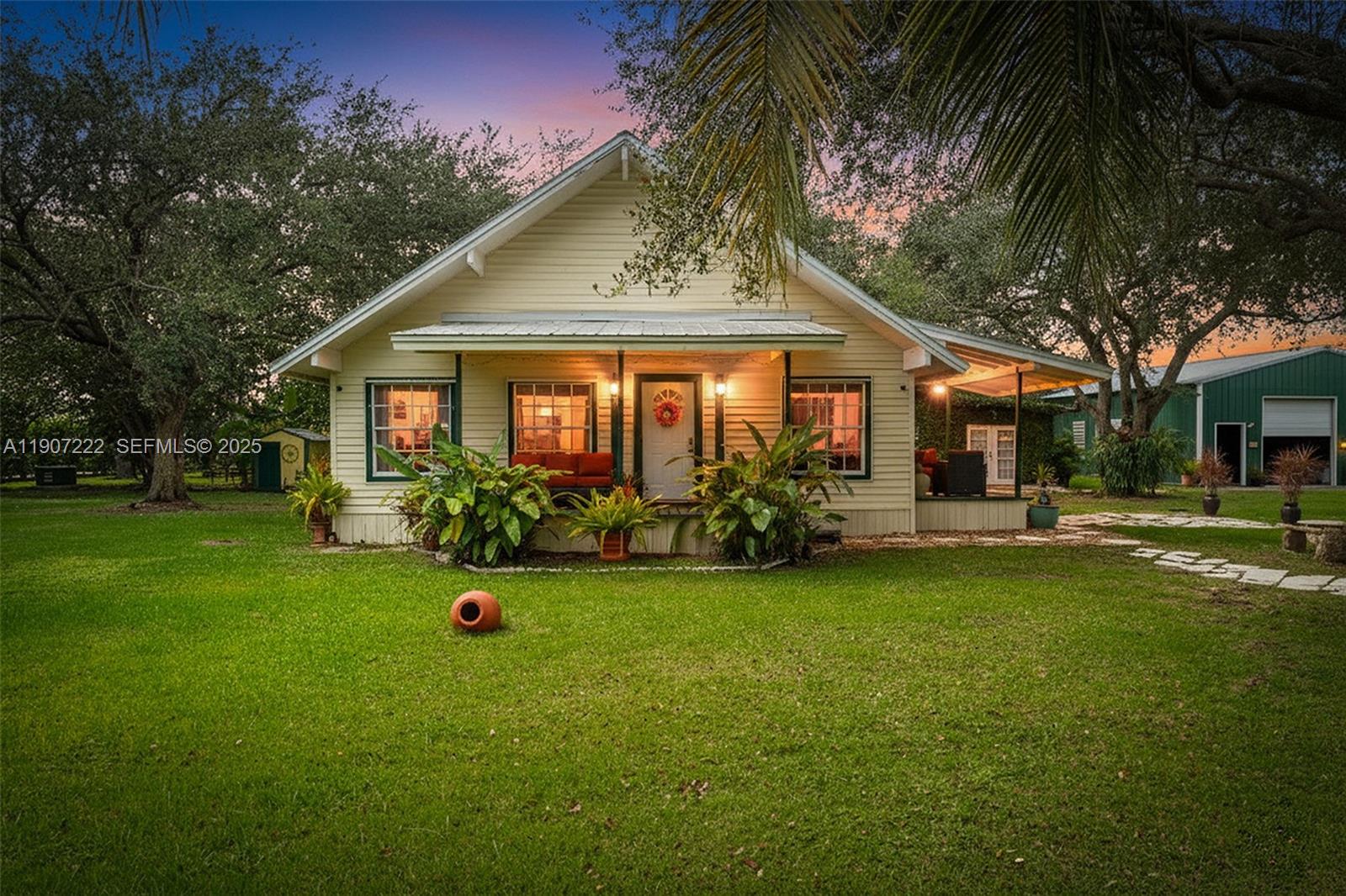 a front view of a house with a garden and trees