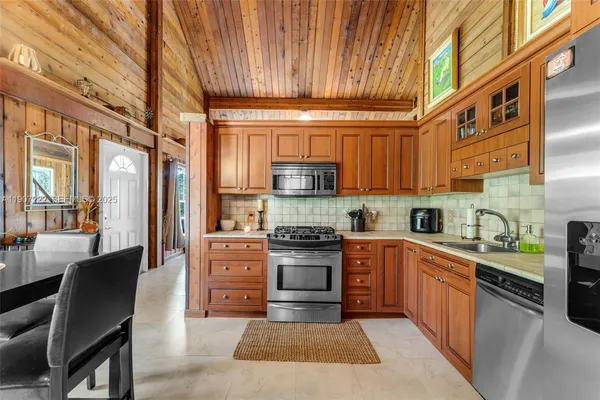 a kitchen with stainless steel appliances granite countertop a stove a sink dishwasher and a refrigerator