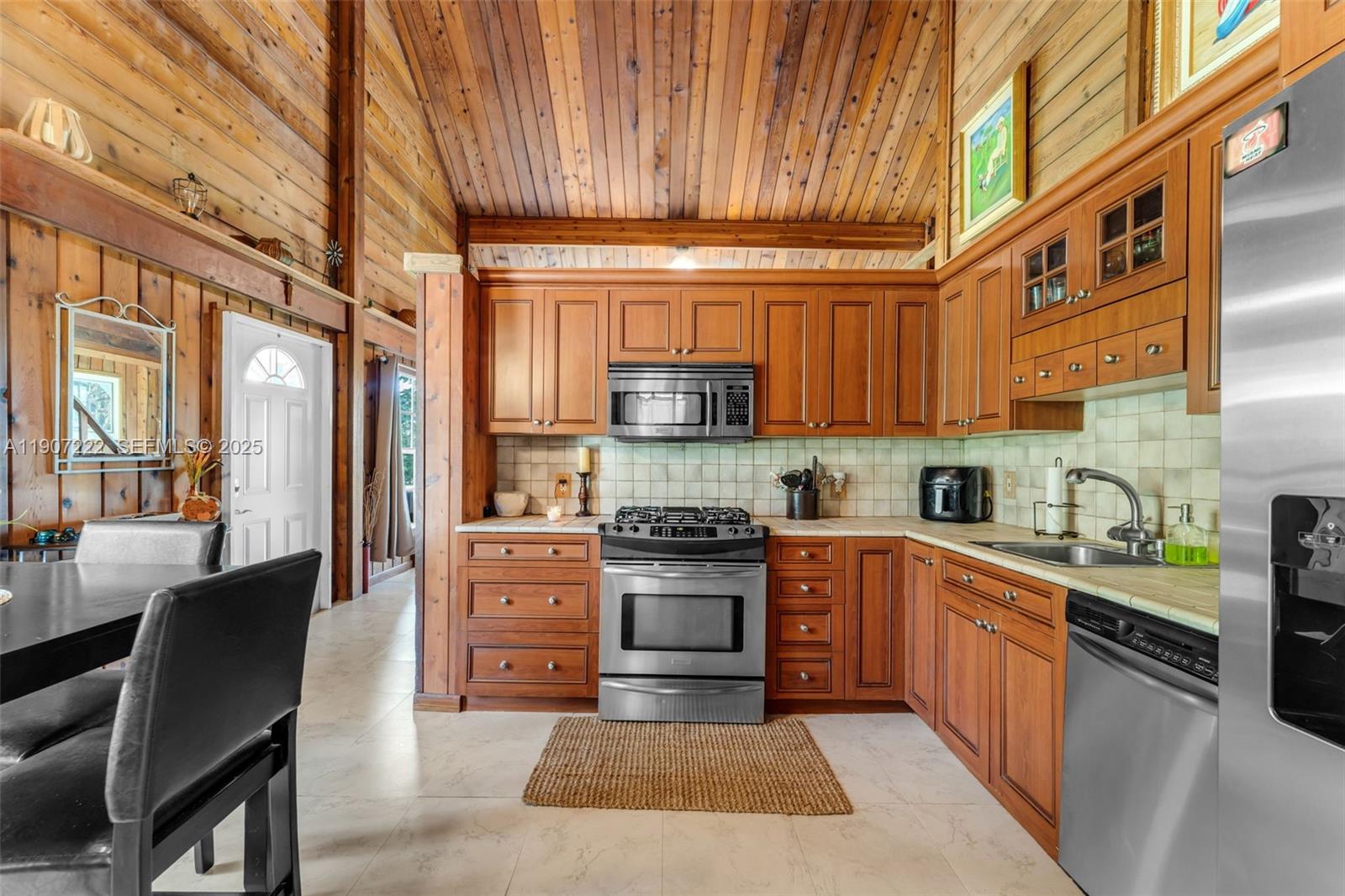18895 Southwest 212th Street Miami, FL 33187 - Photo 14 of 36 a kitchen with stainless steel appliances granite countertop a stove a sink dishwasher and a refrigerator