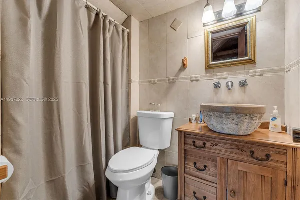a bathroom with a toilet a sink and a mirror
