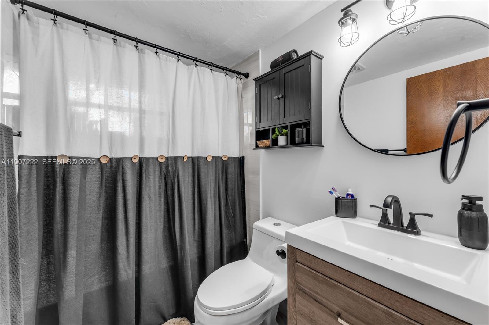 18895 Southwest 212th Street Miami, FL 33187 - Photo 21 of 36 a bathroom with a sink a toilet and a mirror