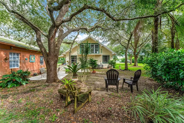 a view of a chair and table in backyard of the house