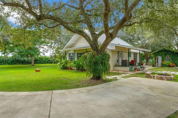 a front view of a house with a yard and trees