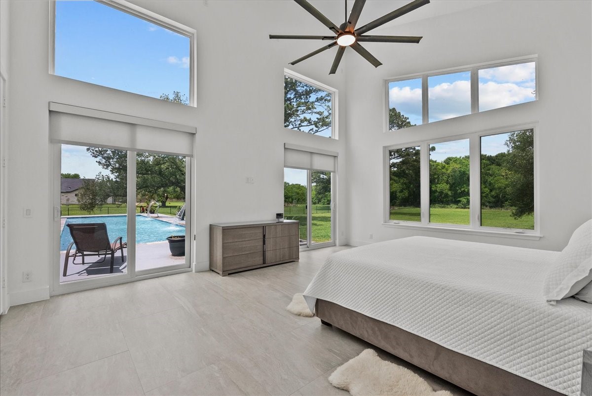 7627 Scott Avenue Manvel, TX 77578 - Photo 23 of 50 25ft ceilings, clerestory windows, and a modern designer fan highlight the expansive primary suite.