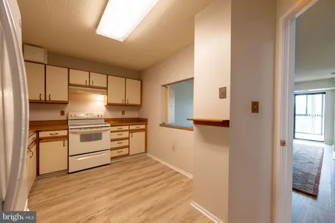 a kitchen with a refrigerator stove top oven and cabinets