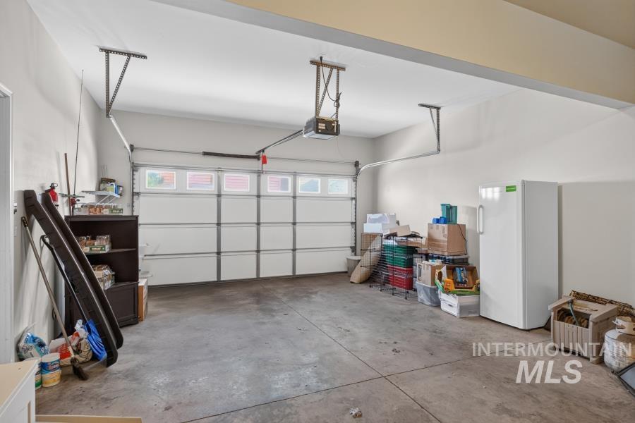 1337 Bristol Road Moscow, ID 83843 - Photo 23 of 28 Two-car garage featuring a sectional garage door with upper window inserts and an automatic opener