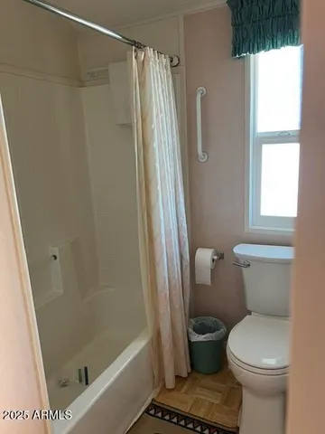 a bathroom with a toilet and a shower
